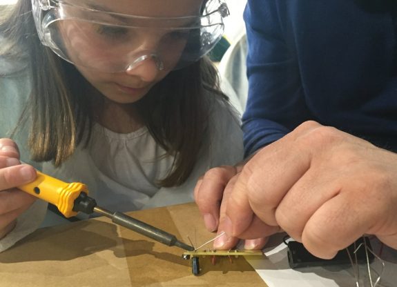 Kathryn carefully soldering capacitors