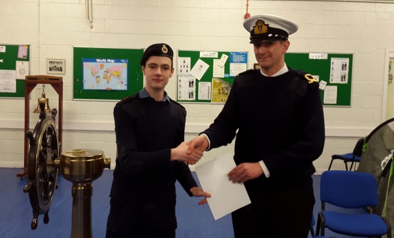 Sub Lieutenant (SCC) R Calver RNR presenting the pass certificate to Joseph.